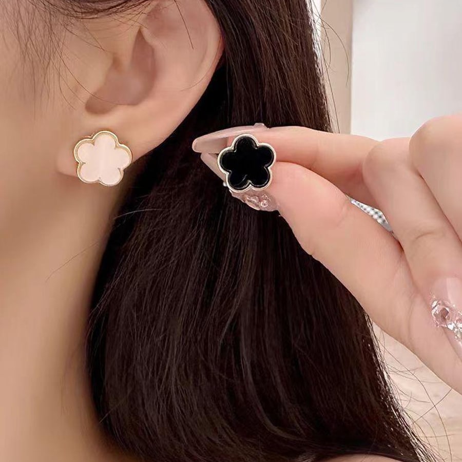 Aretes dorados de trebol blanco y negro
