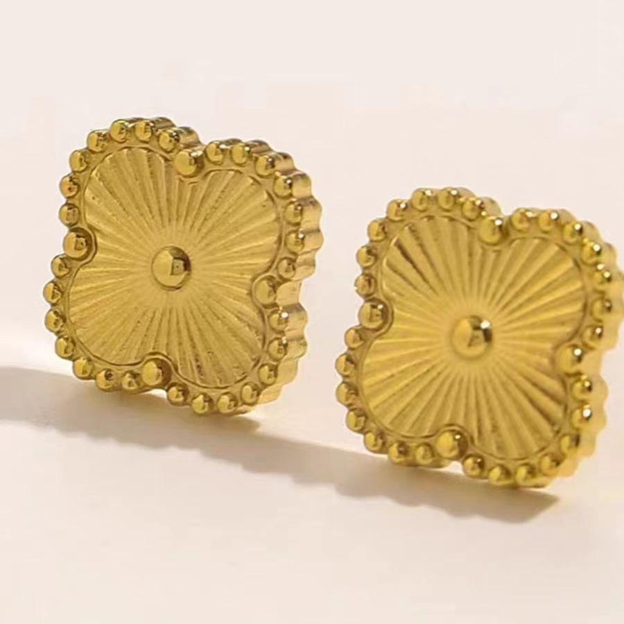Aretes dorados cuadrados con textura floral